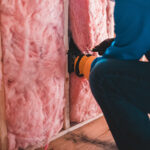 A man installing Interior wall insulation.
